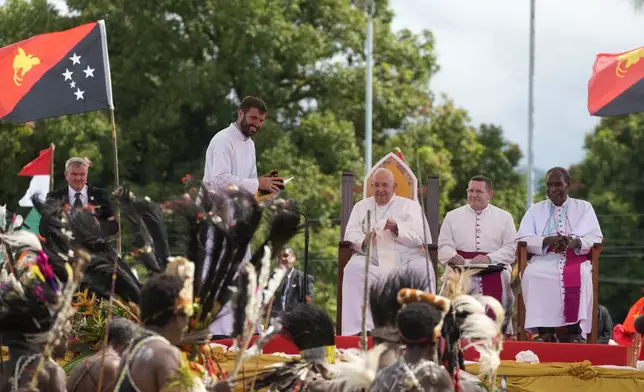 Pope Francis, center, with Father Martin Prado, a missionary of the Institute of the Incarnate Word, second from left, and the bishop of Vanimo Francis Meli, right, attends a meeting with faithful in Vanimo, Papua New Guinea, Sunday, Sept. 8, 2024. Pope Francis celebrated the Catholic Church of the peripheries on Sunday as he traveled to the remote jungles of Papua New Guinea, bringing with him a ton of medicine and toys and a message of love overcoming violence for the people who live there.(AP Photo/Gregorio Borgia)