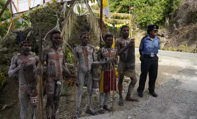 Papuan indigenous people wait for Pope Francis in Vanimo, Papua New Guinea, Sunday, Sept. 8, 2024. Pope Francis celebrated the Catholic Church of the peripheries on Sunday as he traveled to the remote jungles of Papua New Guinea, bringing with him a ton of medicine and toys and a message of love overcoming violence for the people who live there.(AP Photo/Gregorio Borgia)