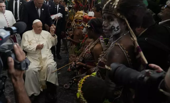 Pope Francis meets performers outside the APEC Haus in Port Moresby, Saturday, Sept. 7, 2024, where Pope Francis and Papua New Guinea's Governor General Bob Dadae attended a traditional dance performance. As a second leg of his 11-day trip to Asia and Oceania Pope Francis's visit to Papua New Guinea will take him to a remote part of the South Pacific island nation where Christianity is a recent addition to traditional spiritual beliefs developed over millennia. (AP Photo/Gregorio Borgia)