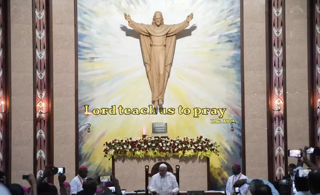 Pope Francis, center, attends a meeting with the bishops of Papua New Guinea and Solomon Islands, priests, deacons, consecrated persons, seminarians and catechists in the Shrine of Mary Help of Christians. in Port Moresby, Saturday, Sept. 7, 2024. Pope Francis called Saturday for an end to tribal conflicts that have wracked Papua New Guinea for decades and appealed for equitable development of its natural resources during a visit that also surfaced the country's problem of violence against women. (AP Photo/Gregorio Borgia)