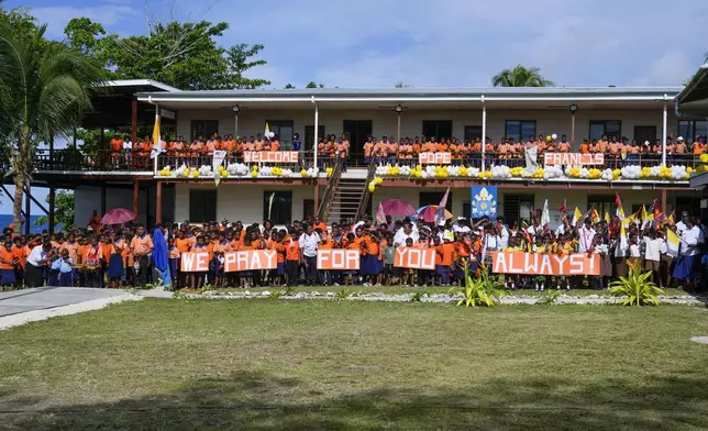 The pupils of the Holy Trinity Humanities School in Baro, near Vanimo, Papua New Guinea, wait for Pope Francis, Sunday, Sept. 8, 2024. Pope Francis celebrated the Catholic Church of the peripheries on Sunday as he traveled to the remote jungles of Papua New Guinea, bringing with him a ton of medicine and toys and a message of love overcoming violence for the people who live there.(AP Photo/Gregorio Borgia)