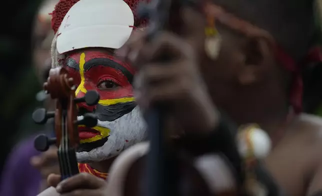 Performers listen to speeches outside the APEC Haus in Port Moresby, Saturday, Sept. 7, 2024, where Pope Francis and Papua New Guinea's Governor General Bob Dadae attended a traditional dance performance. As a second leg of his 11-day trip to Asia and Oceania Pope Francis's visit to Papua New Guinea will take him to a remote part of the South Pacific island nation where Christianity is a recent addition to traditional spiritual beliefs developed over millennia. (AP Photo/Gregorio Borgia)