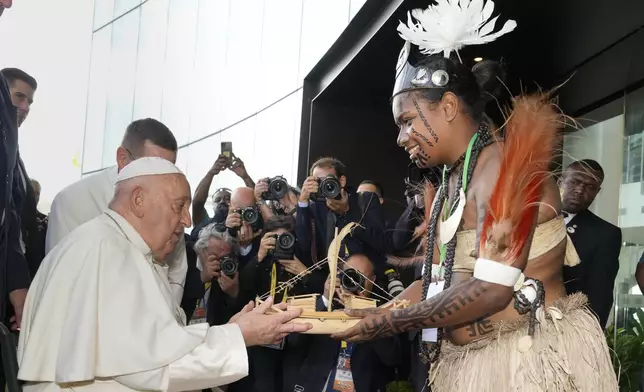 Pope Francis receives souvenir from a Papua New Guinea traditional dancer at APEC Haus in Port Moresby, Papua New Guinea, Saturday, Sept. 7, 2024. (AP Photo/Mark Baker)