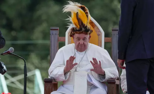 Pope Francis receives a traditional hat during a meeting with faithful in Vanimo, Papua New Guinea, Sunday, Sept. 8, 2024. Pope Francis celebrated the Catholic Church of the peripheries on Sunday as he traveled to the remote jungles of Papua New Guinea, bringing with him a ton of medicine and toys and a message of love overcoming violence for the people who live there.(AP Photo/Gregorio Borgia)