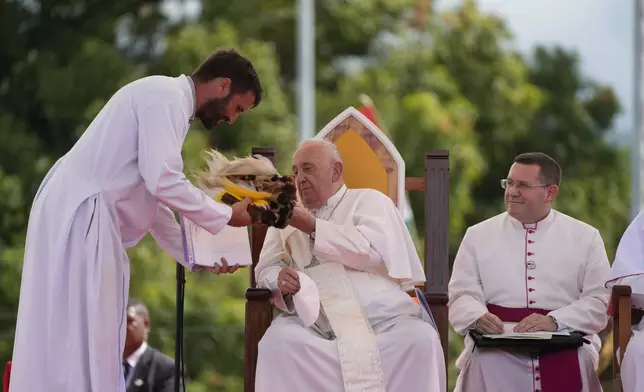 Pope Francis, talks with Father Martin Prado, a missionary of the Institute of the Incarnate Word, left, during a meeting with faithful in Vanimo, Papua New Guinea, Sunday, Sept. 8, 2024. Pope Francis celebrated the Catholic Church of the peripheries on Sunday as he traveled to the remote jungles of Papua New Guinea, bringing with him a ton of medicine and toys and a message of love overcoming violence for the people who live there.(AP Photo/Gregorio Borgia)