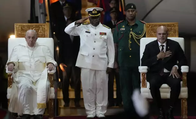 Pope Francis, left, is welcomed by Papua New Guinea's deputy Prime Minister John Rosso, right, and rear-Admiral Philip Polewara, center, as he arrives at Port Moresby's "Jackson" International Airport, Friday, Sept. 6, 2024. As a second leg of his 11-day trip to Asia and Oceania Pope Francis's visit to Papua New Guinea will take him to a remote part of the South Pacific island nation where Christianity is a recent addition to traditional spiritual beliefs developed over millennia.(AP Photo/Gregorio Borgia)