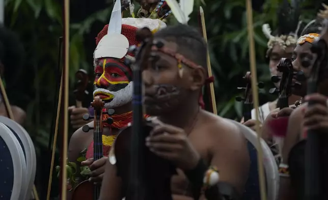 Performers listen to speeches outside the APEC Haus in Port Moresby, Saturday, Sept. 7, 2024, where Pope Francis and Papua New Guinea's Governor General Bob Dadae attended a traditional dance performance. As a second leg of his 11-day trip to Asia and Oceania Pope Francis's visit to Papua New Guinea will take him to a remote part of the South Pacific island nation where Christianity is a recent addition to traditional spiritual beliefs developed over millennia. (AP Photo/Gregorio Borgia)