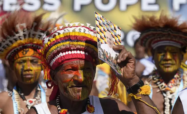 Men wear traditional headdress as Pope Francis holds a holly mass at Sir John Guise Stadium in Port Moresby, Papua New Guinea, Sunday, Sept. 8, 2024. (AP Photo/Mark Baker)