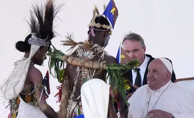 Pope Francis meets with people in traditional dress after giving an address during meeting with young people in the Sir John Guise Stadium in Port Moresby, Papua New Guinea, Monday, Sept. 9, 2024. (AP Photo/Mark Baker)