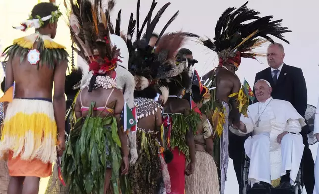 Pope Francis meets with people in traditional dress after giving an address during meeting with young people in the Sir John Guise Stadium in Port Moresby, Papua New Guinea, Monday, Sept. 9, 2024. (AP Photo/Mark Baker)