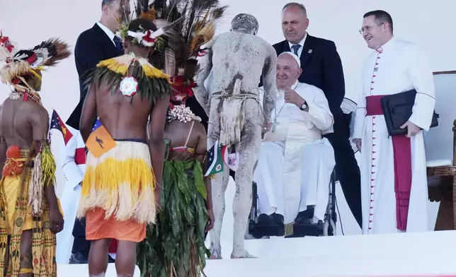 Pope Francis, third right, meets with people in traditional dress after giving an address during meeting with young people in the Sir John Guise Stadium in Port Moresby, Papua New Guinea, Monday, Sept. 9, 2024. (AP Photo/Mark Baker)