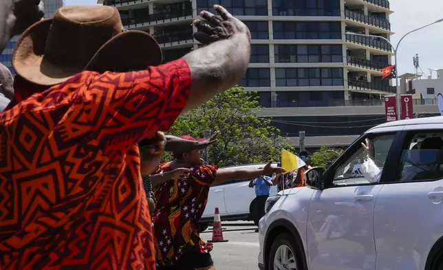 Locals rush to the car carrying Pope Francis as he leaves APEC Haus in Port Moresby, Papua New Guinea, Saturday, Sept. 7, 2024. (AP Photo/Mark Baker)