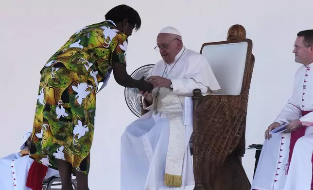 Pope Francis, center, interacts with a woman as gives an address during meeting with young people in the Sir John Guise Stadium in Port Moresby, Papua New Guinea, Monday, Sept. 9, 2024. (AP Photo/Mark Baker)