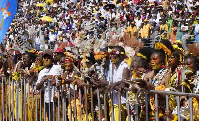 People with traditional headdress and face paint attends a holy mass by Pope Francis at Sir John Guise Stadium in Port Moresby, Papua New Guinea, Sunday, Sept. 8, 2024. (AP Photo/Mark Baker)