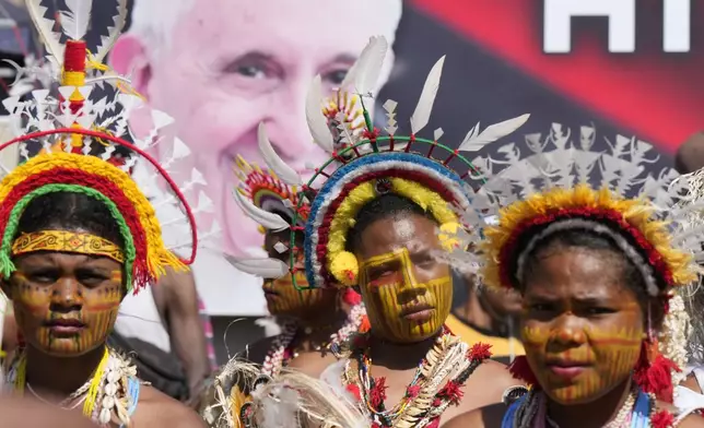 Women with traditional headdress and face paint attends a holy mass by Pope Francis at Sir John Guise Stadium in Port Moresby, Papua New Guinea, Sunday, Sept. 8, 2024. (AP Photo/Mark Baker)