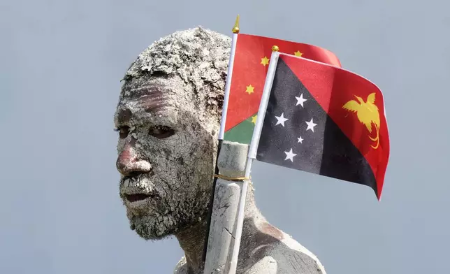 An Asaro mudman stands in front of the stage as Pope Francis gives an address during meeting with young people in the Sir John Guise Stadium in Port Moresby, Papua New Guinea, Monday, Sept. 9, 2024. (AP Photo/Mark Baker)