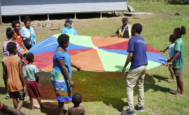 In this undated photo provided by UNICEF PNG, East Sepik massacre survivors play a game at a care center in Angoram, Papua New Guinea. (Noreen Chambers/UNICEF PNG via AP)