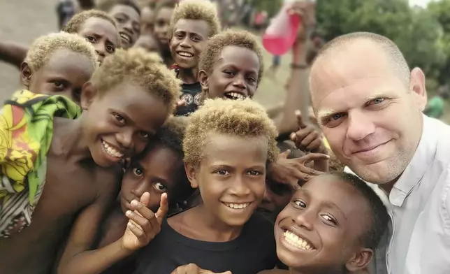 This undated photo provided by Fr Tomas Ravaioli shows young villagers posing for a photo with him in Rabaul, Papua New Guinea. (Fr Tomas Ravaioli via AP)