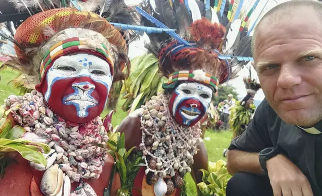 This undated photo provided by Fr Tomas Ravaioli shows local villagers posing for a photo with him in Goroka, Papua New Guinea. (Fr Tomas Ravaioli via AP)