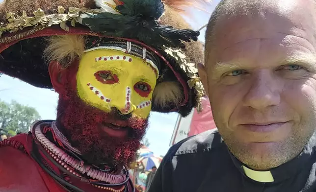 This undated photo provided by Fr Tomas Ravaioli shows a local villager posing for a photo with him in Goroka, Papua New Guinea. (Fr Tomas Ravaioli via AP)