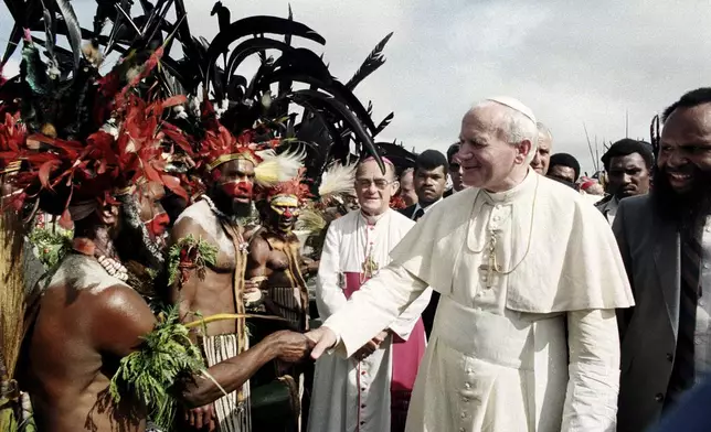 FILE - Pope John Paul II is greeted by Papua New Guinea Highland natives on his visit to Mt. Hagen, Papua New Guinea, on May 8, 1984. (AP Photo, File)