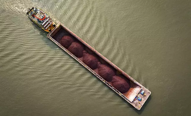 A tugboat pushes a barge with a light load across the Paraguay River in Mariano R. Alonso, Paraguay, Monday, Sept. 9, 2024. Water levels have plunged to their lowest-ever level amid a drought, according to Paraguay's Meteorology and Hydrology Office. (AP Photo/Jorge Saenz)