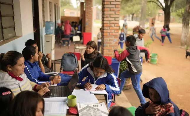 Eighth graders take notes during a geography class at the Nueva Asuncion public school in Chaco-i, Paraguay, Tuesday, Aug. 20, 2024. Paraguay seeks to roll out its first national sex-ed curriculum in September 2024. (AP Photo/Jorge Saenz)