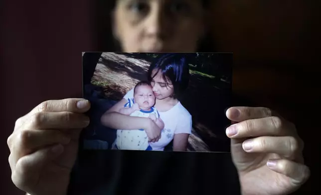 Diana Zalazar, 39, shows a photo of her with her son Ato at her home in Lambare, Paraguay, Friday, Aug. 23, 2024. Zalazar said she got pregnant after having sex with her first partner when she was 14 years old but that no one had talked to her about the risks of pregnancy or sexually transmitted diseases. (AP Photo/Jorge Saenz)