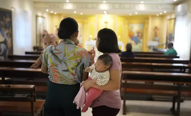 Teenage women hold their babies before attending Mass at the Catholic shelter for young mothers, Casa Rosa Maria, in Asuncion, Paraguay, Monday, Aug. 19, 2024. Abortion is punishable by prison time with no exemptions in Paraguay, which has the highest rate of teenage pregnancy in South America. (AP Photo/Jorge Saenz)