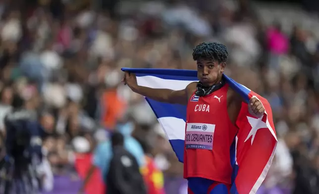 Cuba's Robiel Yankiel Sol Cervantes celebrates after winning the men's long jump T47 during the 2024 Paralympics, Tuesday, Sept. 3, 2024, in Paris, France. (AP Photo/Thibault Camus)