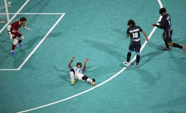 Argentina's Osvaldo Fernandez lies on the floor next to France's Frederic Villeroux, second right, during the blind football gold medal match at the 2024 Paralympics, Saturday, Sept. 7, 2024, in Paris, France. (AP Photo/Christophe Ena)