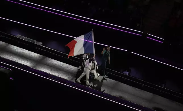 Members of the French delegation parade during the closing ceremony of the 2024 Paralympics, Sunday, Sept. 8, 2024, in Paris, France. (AP Photo/Christophe Ena)