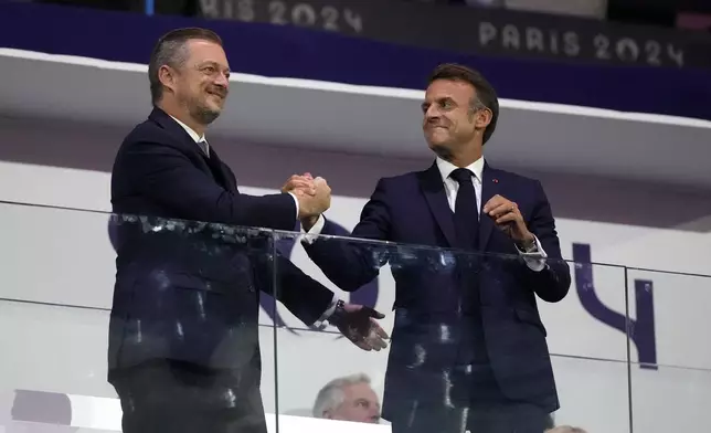 French President Emmanuel Macron, right, and President of the International Paralympic Committee Andrew Parsons shake hands during the closing ceremony for the 2024 Paralympics, Sunday, Sept. 8, 2024, in Paris, France. (AP Photo/Michel Euler)