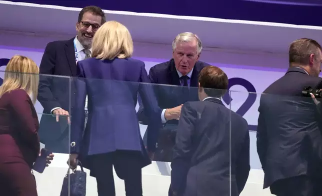 French Prime Minister Michel Barnier speaks with French President Emmanuel Macron, foreground right, and Macron's wife, Brigitte Macron, foreground left, at the closing ceremony of the 2024 Paralympics, Sunday, Sept. 8, 2024, in Paris, France. (AP Photo/Michel Euler)