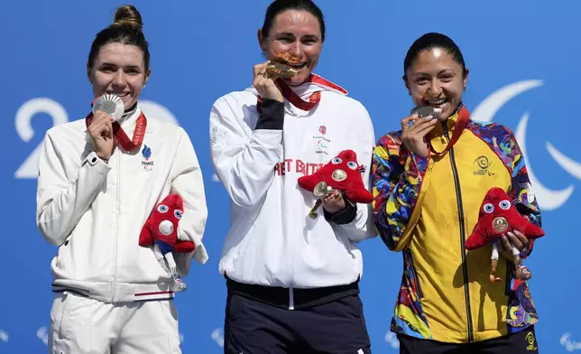 Britain's Sarah Storey, centre, France's Heidi Gaugain, left, and Colombia's Paula Andrea Ossa Veloza celebrate with their gold, silver, and bronze medal after the women's C4-5 road race during the 2024 Paralympics, Friday, Sept. 6, 2024, in Clichy-sous-Bois, France. (AP Photo/Aurelien Morissard)