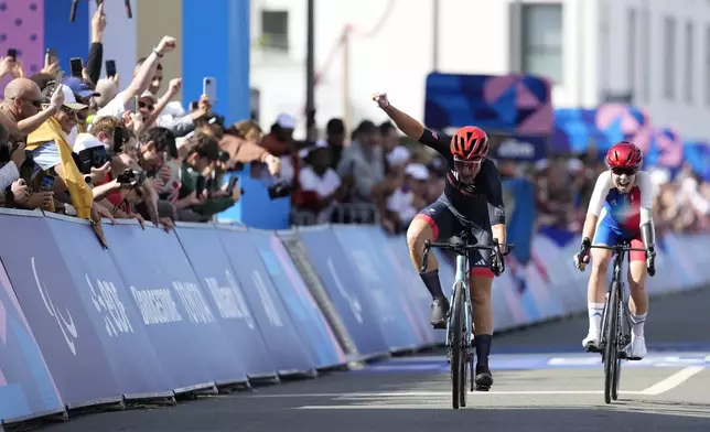 Britain's Sarah Storey, left, celebrates as she wins the gold medal in the women's C4-5 road race during the 2024 Paralympics, Friday, Sept. 6, 2024, in Clichy-sous-Bois, France. (AP Photo/Aurelien Morissard)