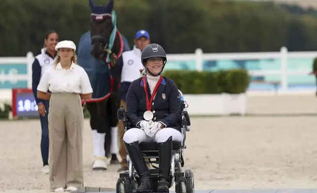 Roxanne Trunnell of the U.S. celebrates her silver medal in the equestrian grade I individual event at the Palace of Versailles, at the 2024 Paralympics, Tuesday, Sept. 3, 2024. (AP Photo/Kileigh Kane)