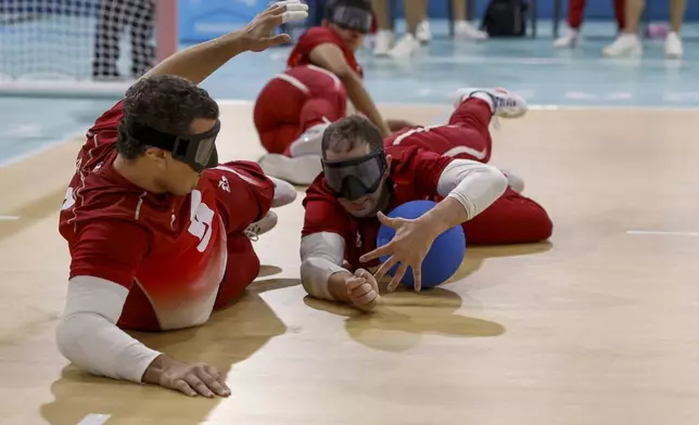 France's Haris Neilmarlija,right, dives in front of teammate Kada Boualia to prevent the ball from going into the goal during the mens' United States versus France goalball game at the Paralympic Games in Paris, Saturday, Aug. 31, 2024. (AP Photo/Felix Scheyer)