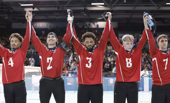 From left, U.S. team goalball players Tre'shaun Faison, Tyler Merren, Zion Walker, Christian King and Matt Simpson raise their hands after a 5-4 victory over the French men's goalball team during the Paralympic Games in Paris, Saturday, Aug. 31, 2024. (AP Photo/Felix Scheyer)