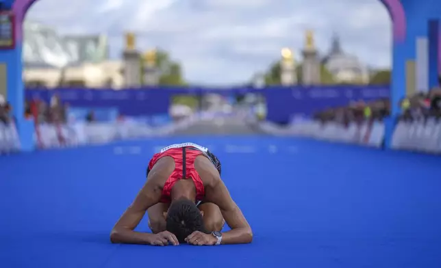 Japan's Tadashi Horikoshi lies on the ground after the men's marathon T12 at the 2024 Paralympics, Sunday, Sept. 8, 2024, in Paris, France. (AP Photo/Thibault Camus)