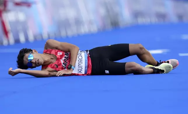 Japan's Yutaka Kumagai lies on the ground after the men's marathon T12 at the 2024 Paralympics, Sunday, Sept. 8, 2024, in Paris, France. (AP Photo/Thibault Camus)