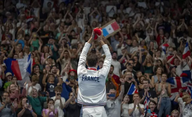 Paralympic athlete Ugo Didier, for France, celebrates at the podium after winning the Men's 400 Freestyle -S9, during the 2024 Paralympics, Thursday, Aug. 29, 2024, in Paris, France. (AP Photo/Emilio Morenatti)