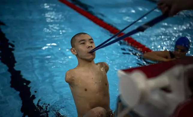 Gus Jinchena, of China, practices the start of the race during a warm up session ahead of a competition, during the 2024 Paralympics, Tuesday, Sept. 3, 2024, in Paris, France. (AP Photo/Emilio Morenatti)