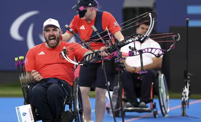 Great Britain's Nathan Macqueen and Jodie Grinham win gold in the Mixed Team Compound Open, during the 2024 Paralympics, Monday, Sept. 2, 2024 in Paris, France. (AP Photo/Leighton Smithwick)