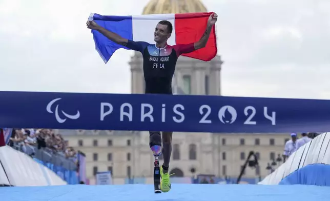 France's Alexis Hanquinquant wins the men's PTS4 Triathlon at the 2024 Paralympics, Monday, Sept. 2, 2024, in Paris, France. (AP Photo/Thibault Camus)