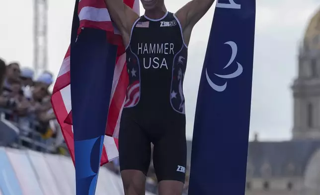 Chris Hammer from the U.S. celebrates after winning the men's PTS5 Triathlon at the 2024 Paralympics, Monday, Sept. 2, 2024, in Paris, France. (AP Photo/Thibault Camus)