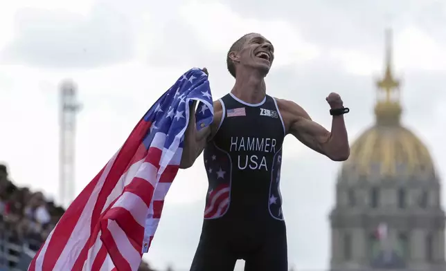 Chris Hammer from the U.S. celebrates after winning the men's PTS5 Triathlon at the 2024 Paralympics, Monday, Sept. 2, 2024, in Paris, France. (AP Photo/Thibault Camus)