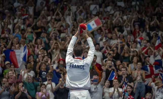 Paralympic athlete Ugo Didier, of France, celebrates at the podium after winning the Men's 400 Freestyle -S9, during the 2024 Paralympics, Thursday, Aug. 29, 2024, in Paris, France. (AP Photo/Emilio Morenatti)