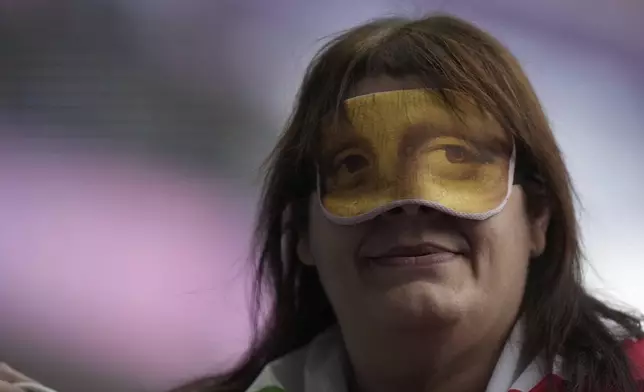 Assunia Legnante from Italy wears a mask after winning the gold medal in the women's shot put F12 final during the 2024 Paralympics, Friday, Sept. 6, 2024, in Paris, France. (AP Photo/Thibault Camus)