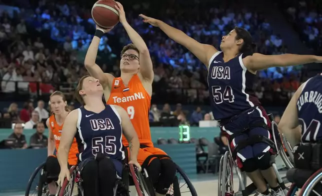 Netherlands' Bo Kramer shoots as Ixhelt Gonzalez from the U.S. defends during the gold medal match of the women's wheelchair basketball between Netherlands and United States, at the 2024 Paralympics, Sunday, Sept. 8, 2024, in Paris, France. (AP Photo/Christophe Ena)